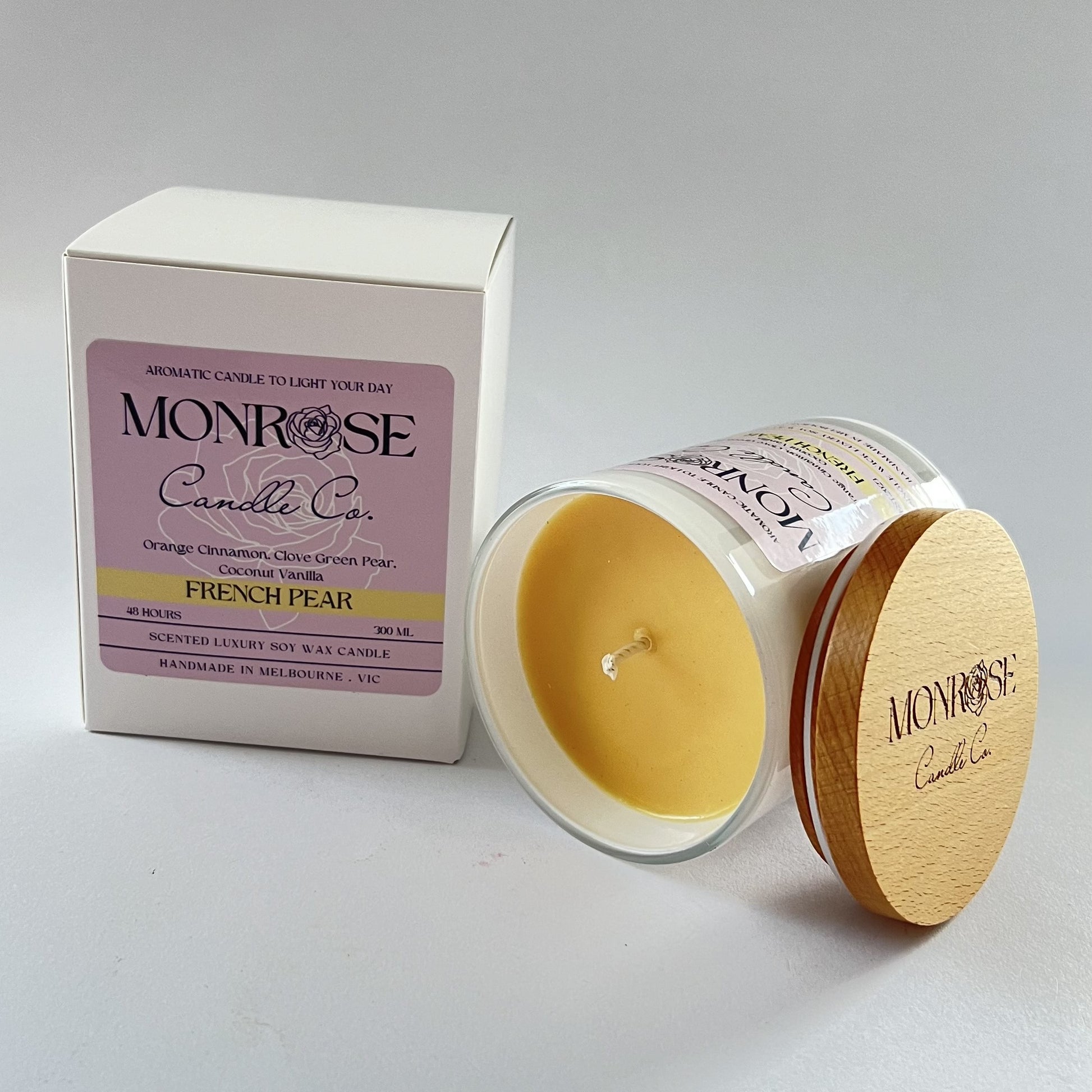 Side view of a white jar candle with "French pear" fragrance and double cotton wicks, containing 265 grams of soy wax and offering 48 hours of burn time.