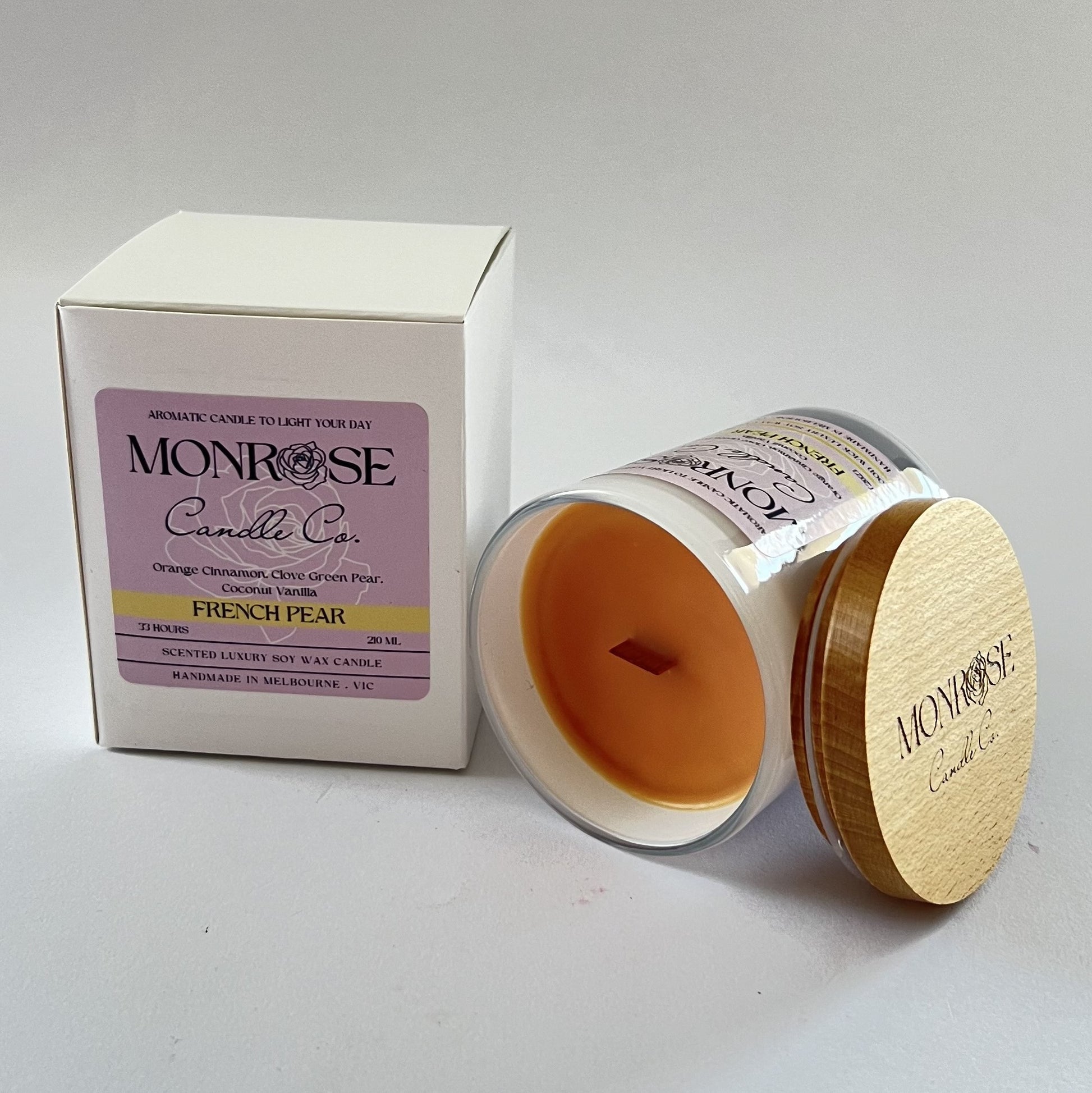 Side view of a White jar candle with "French pear" fragrance and wood wicks, containing 185 grams of soy wax and offering 33 hours of burn time.