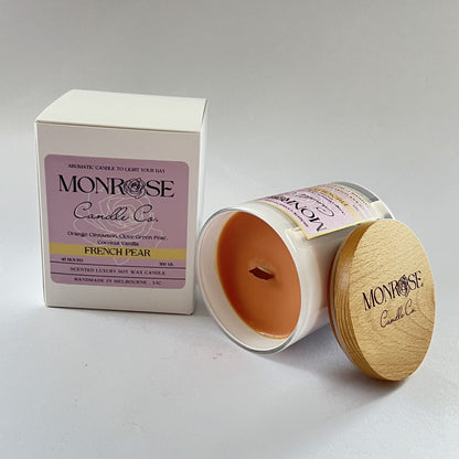 Side view of a White jar candle with "French pear" fragrance and wood wick, containing 265 grams of soy wax and offering 48 hours of burn time.