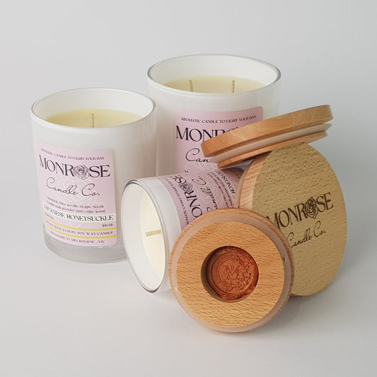 Front view of "Japanese honeysuckle" fragrance candle collection in white jars and  cotton wicks.