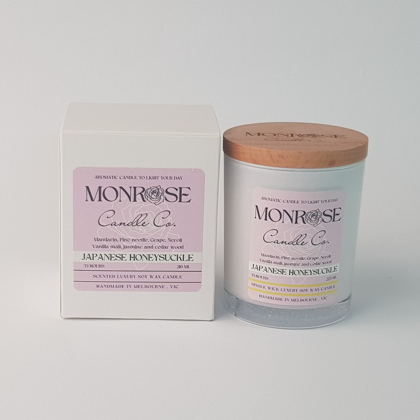Front view of a white jar candle with "Japanese honeysuckle" fragrance and a cotton wick, containing 185 grams of soy wax and offering 33 hours of burn time.