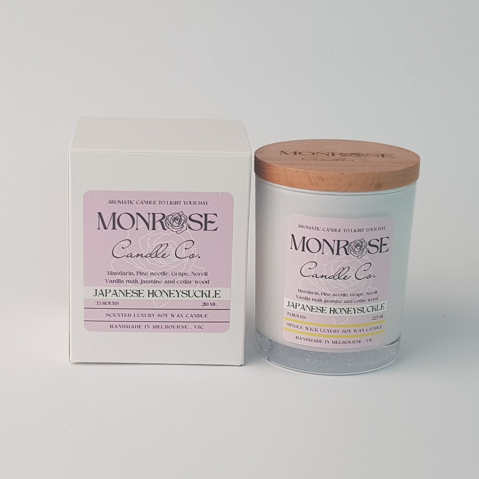Front view of a white jar candle with "Japanese honeysuckle" fragrance and a cotton wick, containing 185 grams of soy wax and offering 33 hours of burn time.