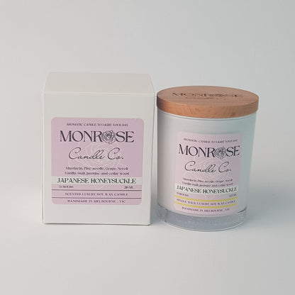 Front view of a white jar candle with "Japanese honeysuckle" fragrance and a cotton wick, containing 185 grams of soy wax and offering 33 hours of burn time.