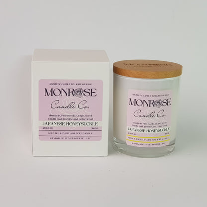 Front view of a white jar candle with "Japanese honeysuckle" fragrance and a cotton wick, containing 265 grams of soy wax and offering 48 hours of burn time.