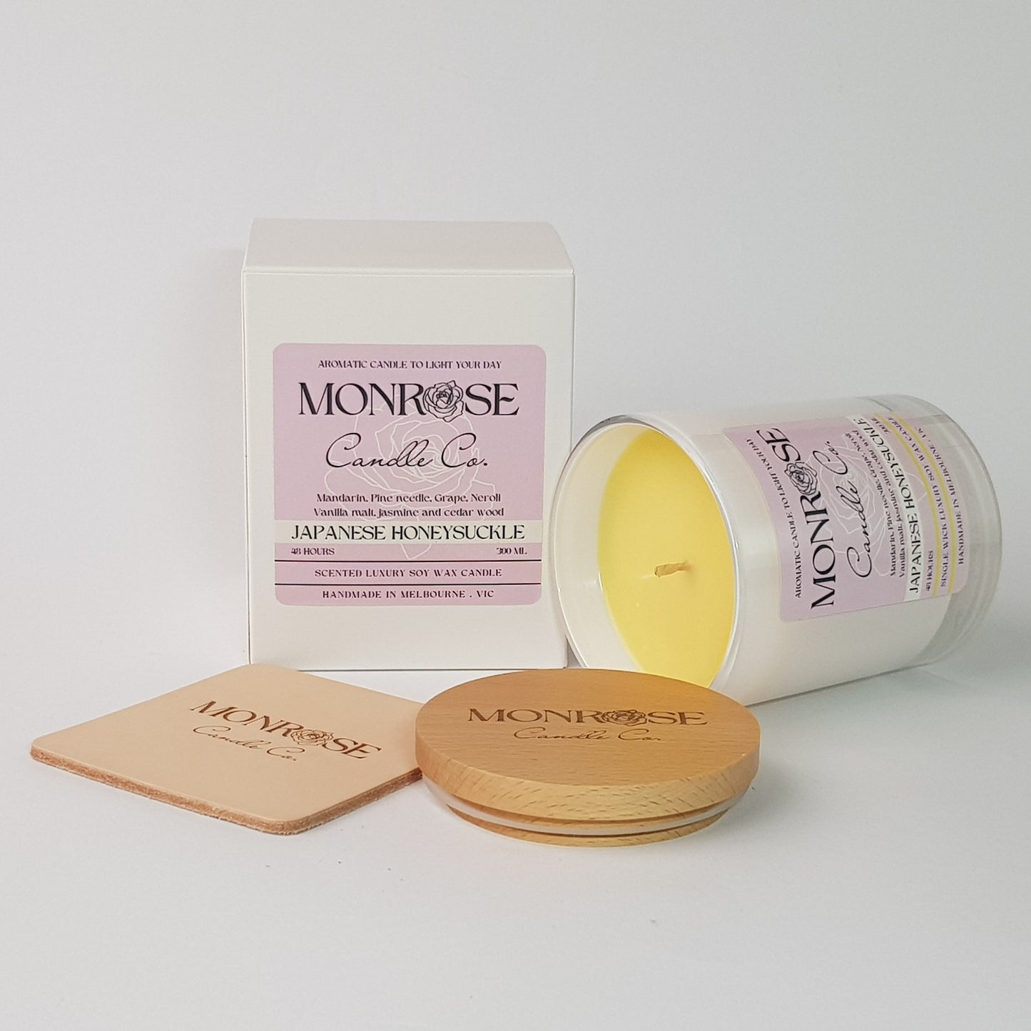 Side view of a white jar candle with "Japanese honeysuckle" fragrance and a cotton wick, containing 265 grams of soy wax and offering 48 hours of burn time.