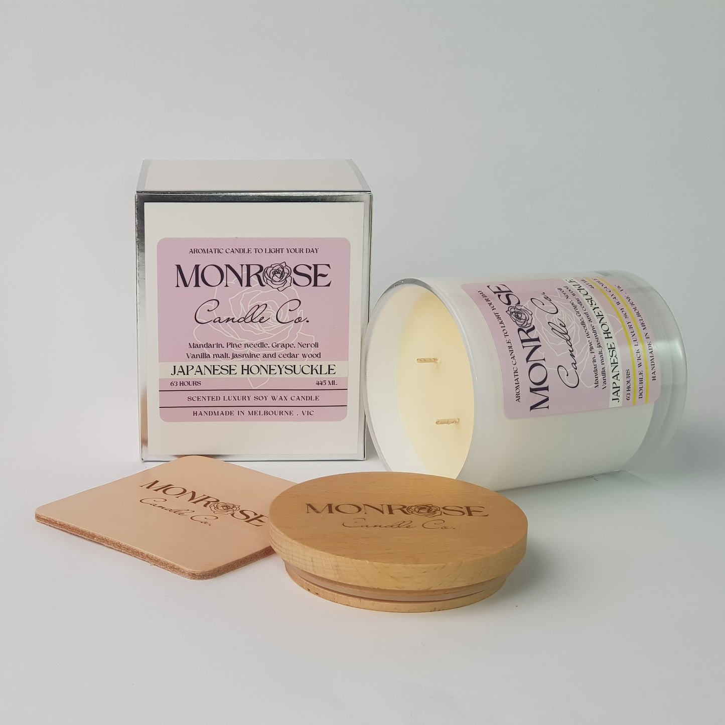 Side view of a black jar candle with "Japanese honeysuckle" fragrance and double cotton wicks, containing 395 grams of soy wax and offering 63 hours of burn time.