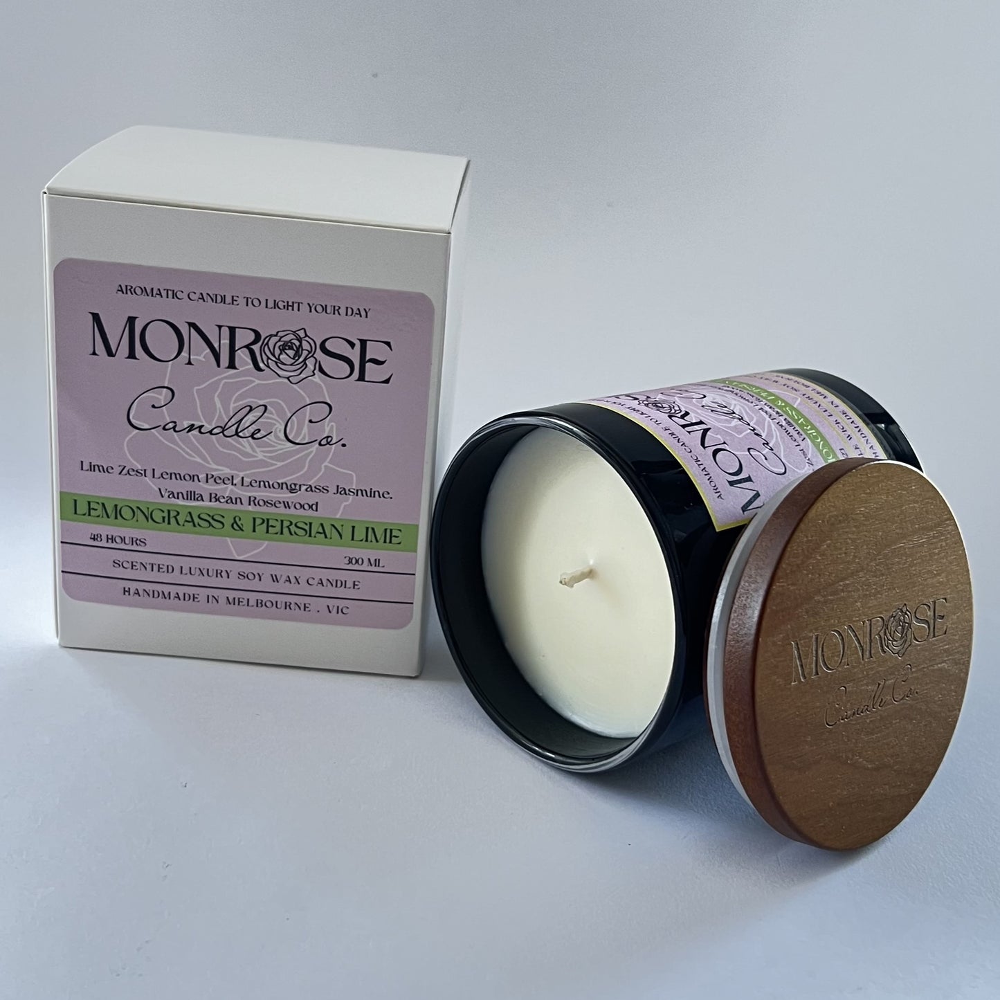 Side view of a black jar candle with "Lemongrass & Persian lime" fragrance and a cotton wick, containing 265 grams of soy wax and offering 48 hours of burn time.