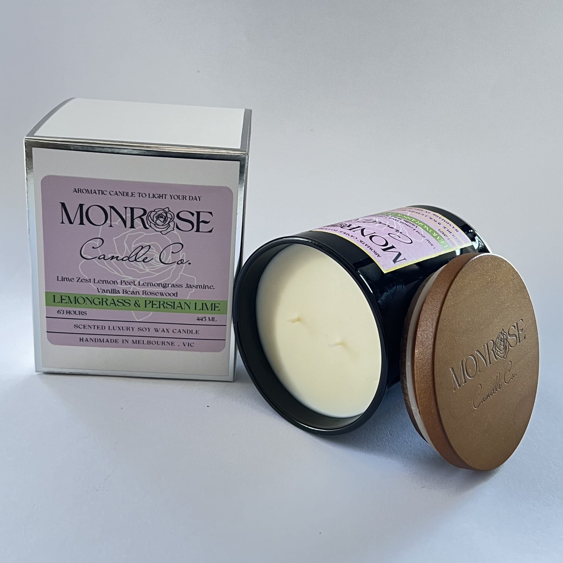 Side view of a black jar candle with "lemongrass & Persian lime" fragrance and double cotton wicks, containing 395 grams of soy wax and offering 63 hours of burn time.