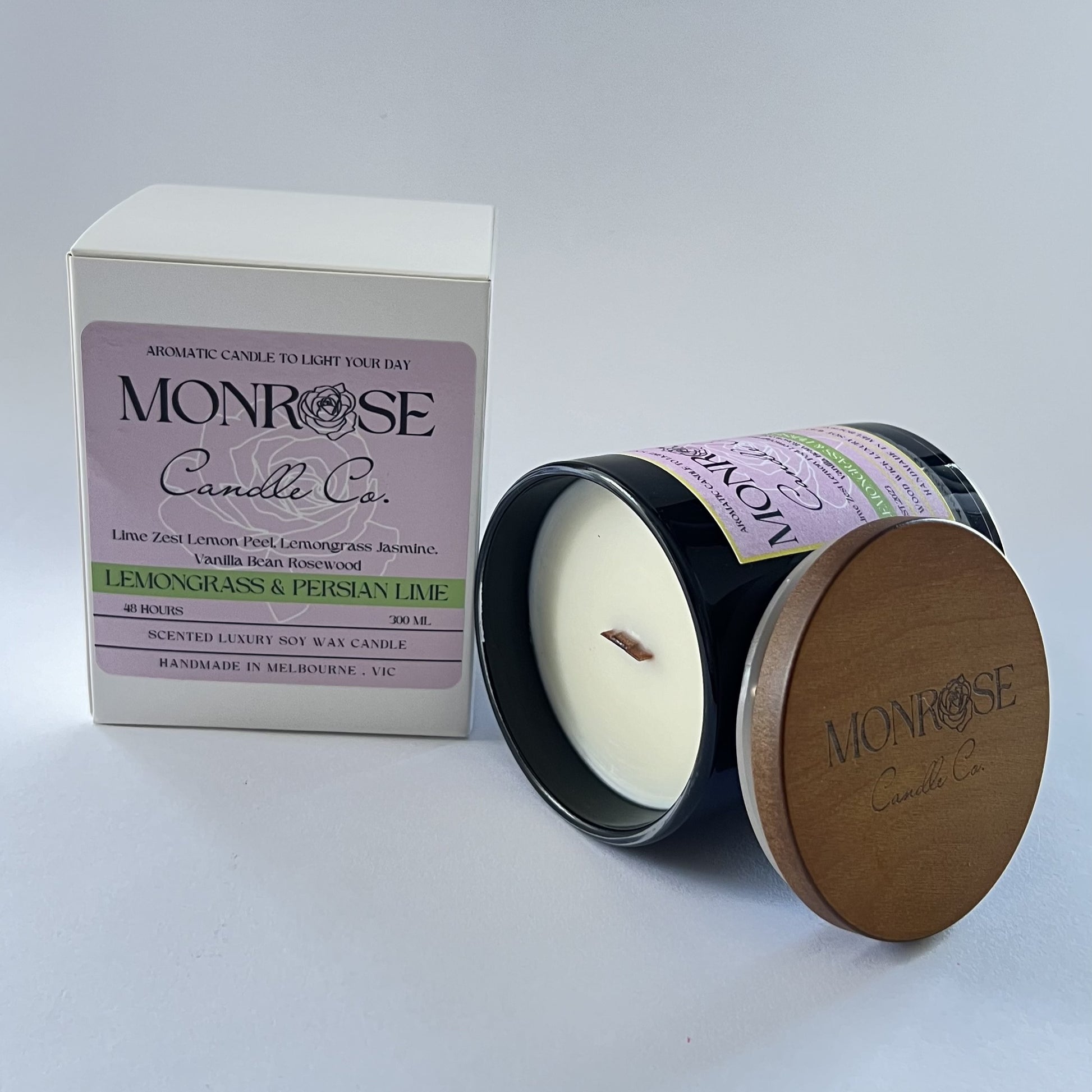 Side view of a black jar candle with "Lemongrass & Persian lime" fragrance and wood wick, containing 265 grams of soy wax and offering 48 hours of burn time.