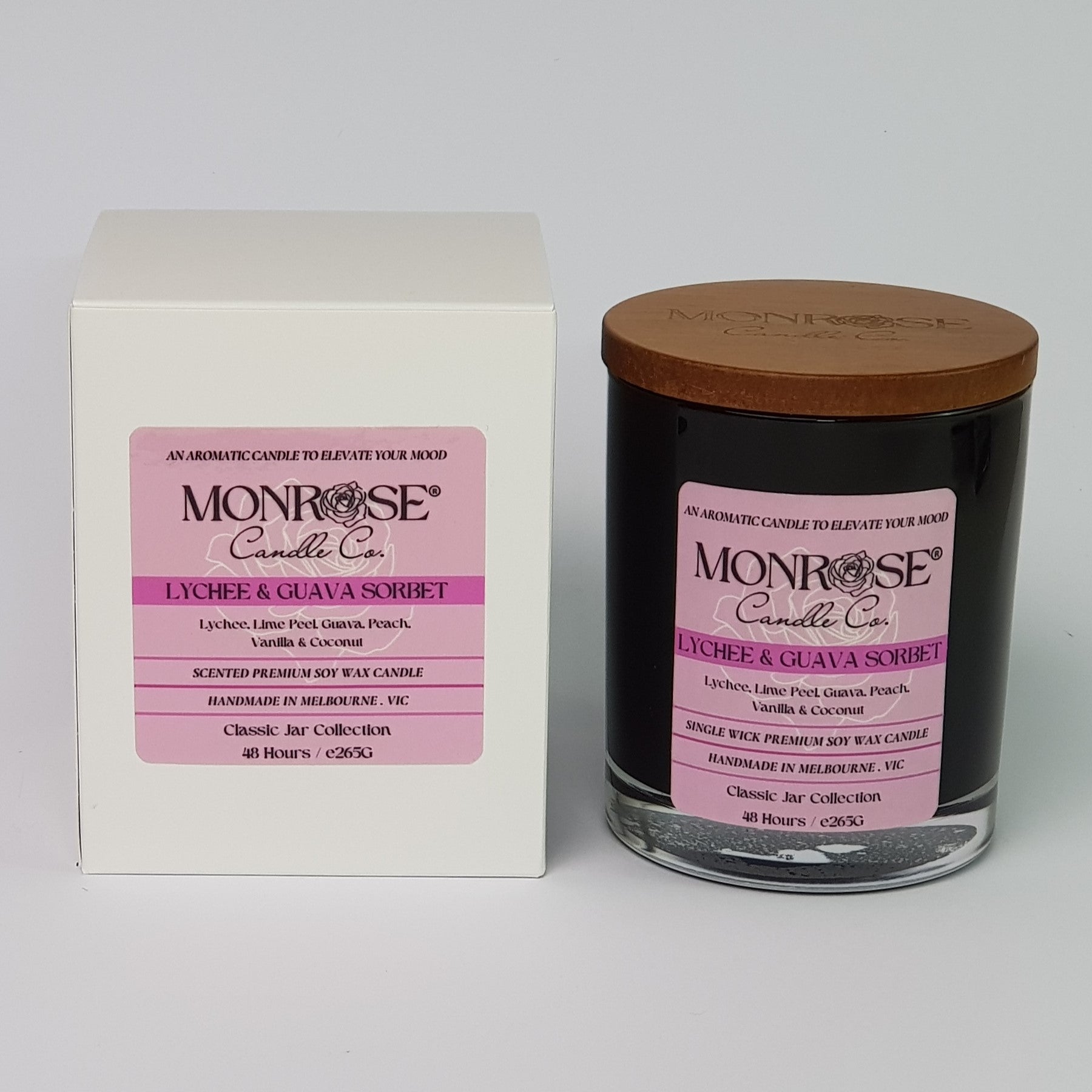 Front view of a container candle with "Lychee & guava sorbet" fragrance in black glass jar and a cotton wick, containing 265 grams of soy wax and offering 48 hours of burn time.