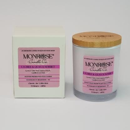 Front view of a container candle with "Lychee & guava sorbet" fragrance in white glass jar and double cotton wicks, containing 185 grams of soy wax and offering 33 hours of burn.