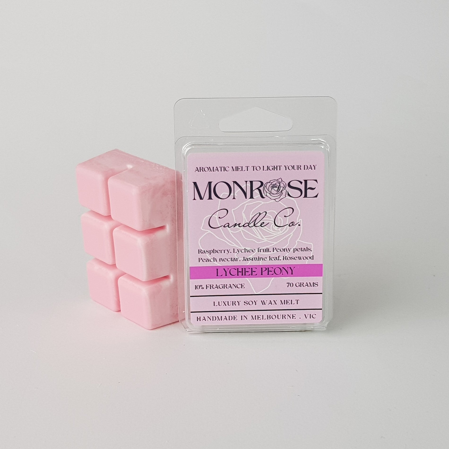 This is the side view of a 6 pack soy wax melt, featuring a pink solid wax melt standing on the left of the packaging. The fragrance of the wax melt is "Lychee peony" and contains 70 grams of soy wax and it is hand crafted in Melbourne, Australia.
