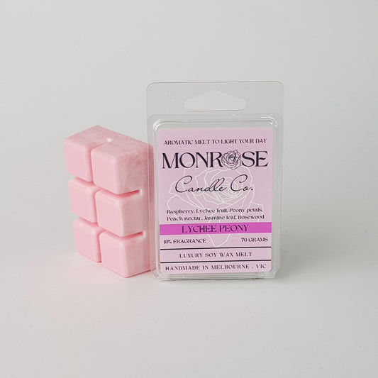 This is the side view of a 6 pack soy wax melt, featuring a pink solid wax melt standing on the left of the packaging. The fragrance of the wax melt is "Lychee peony" and contains 70 grams of soy wax and it is hand crafted in Melbourne, Australia.