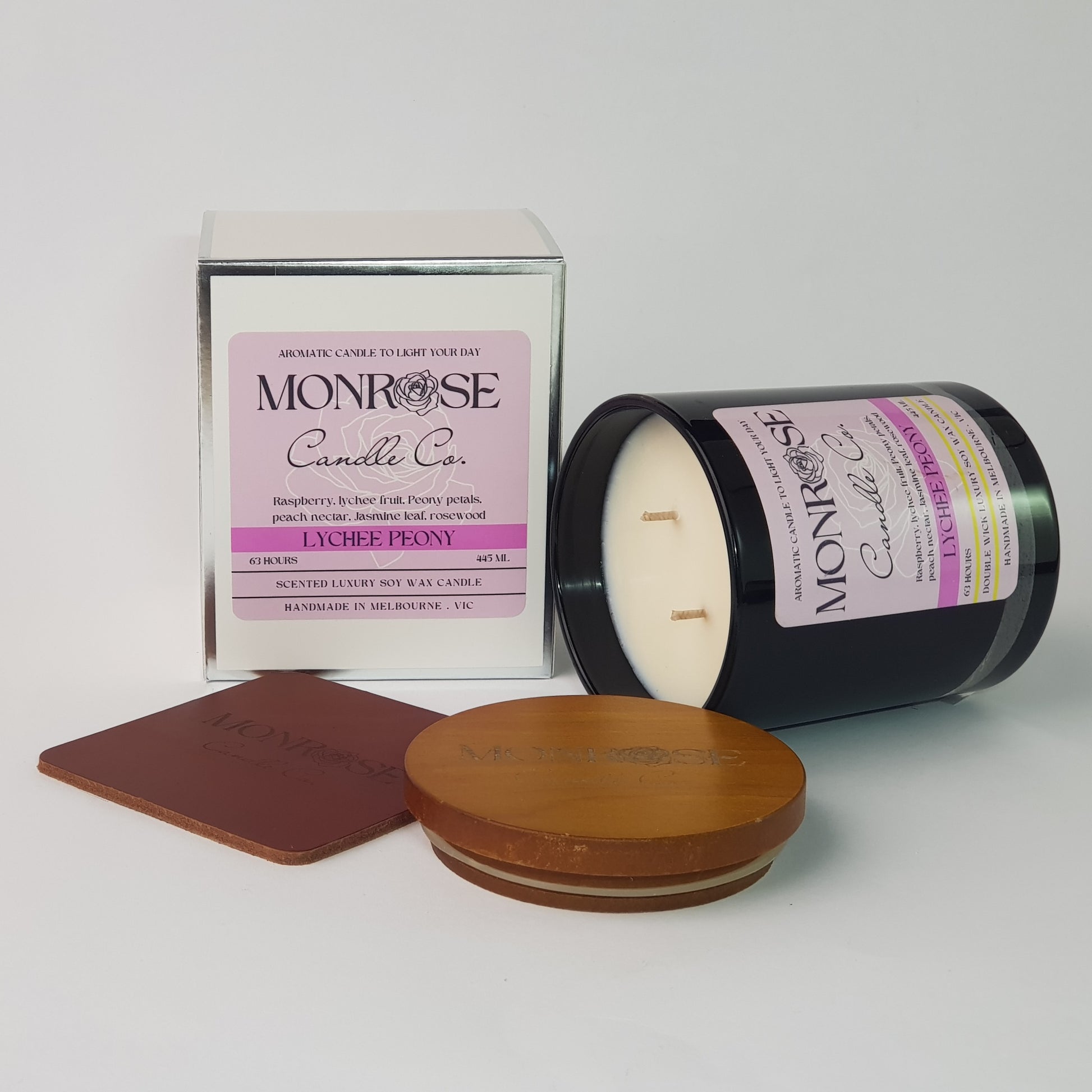 Side view of a black jar candle with "Lychee Peony" fragrance and double cotton wicks, containing 395 grams of soy wax and offering 63 hours of burn time.