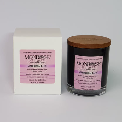 Front view of a container candle with "Marshmallow" fragrance in black glass jar and a cotton wick, containing 265 grams of soy wax and offering 48 hours of burn time.