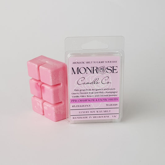 This is the side view of a 6 pack soy wax melt, featuring a pink solid wax melt standing on the left of the packaging. The fragrance of the wax melt is "Pink champagne and exotic fruits" and contains 70 grams of soy wax and it is hand crafted in Melbourne, Australia.