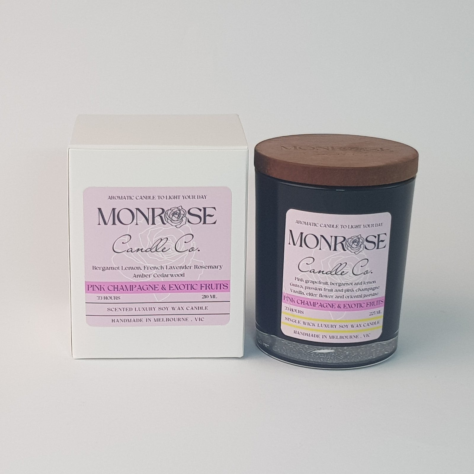 Front view of a black jar candle with pink champagne & exotic fruits fragrance and a cotton wick, containing 185 grams of soy wax and offering 33 hours of burn time.