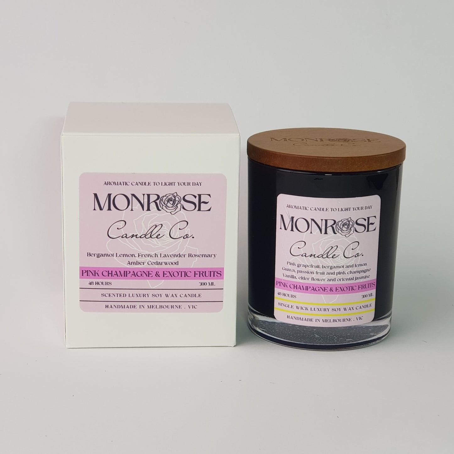 Front view of a black jar candle with pink champagne & exotic fruits fragrance and a cotton wick, containing 265 grams of soy wax and offering 48 hours of burn time.