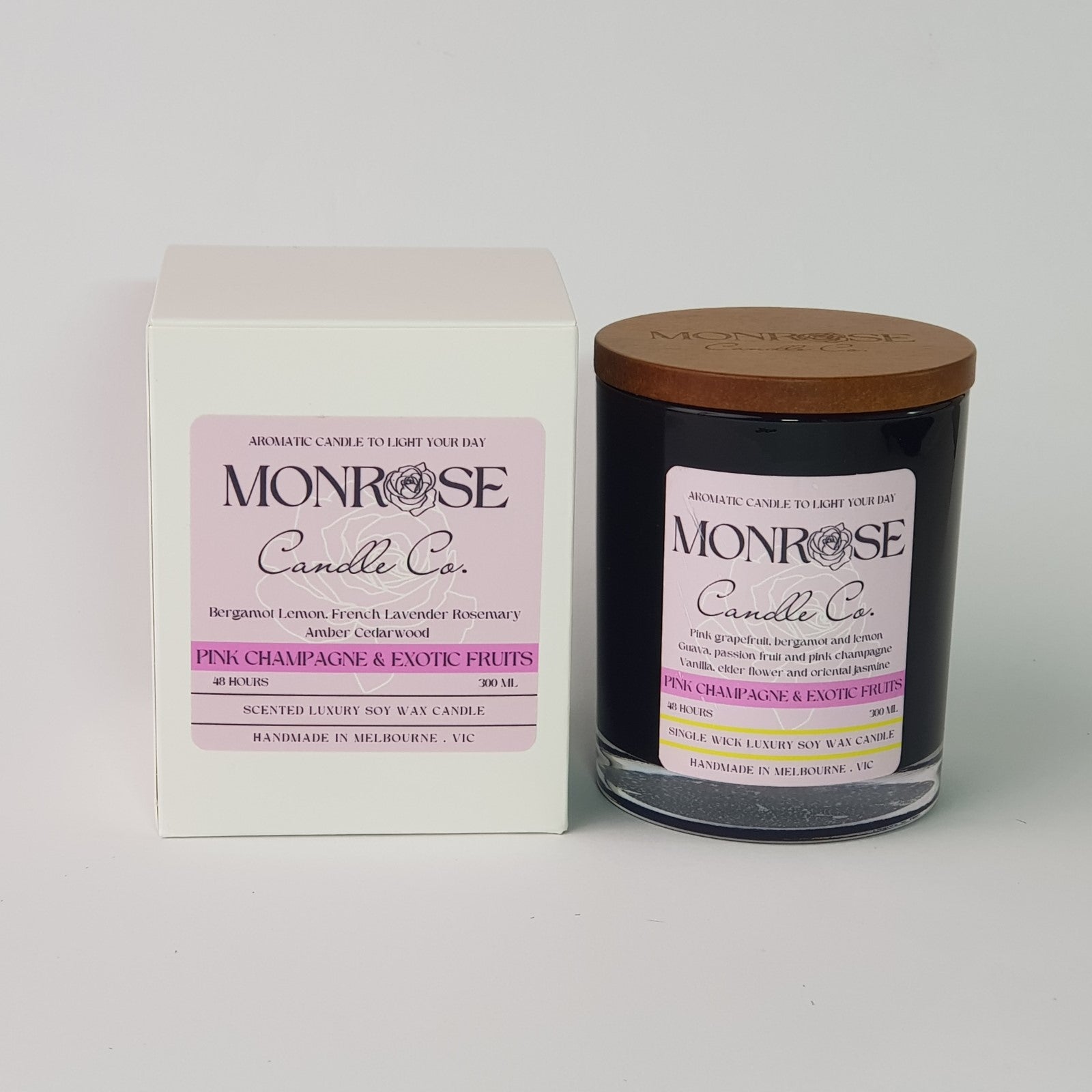 Front view of a black jar candle with pink champagne & exotic fruits fragrance and a cotton wick, containing 265 grams of soy wax and offering 48 hours of burn time.