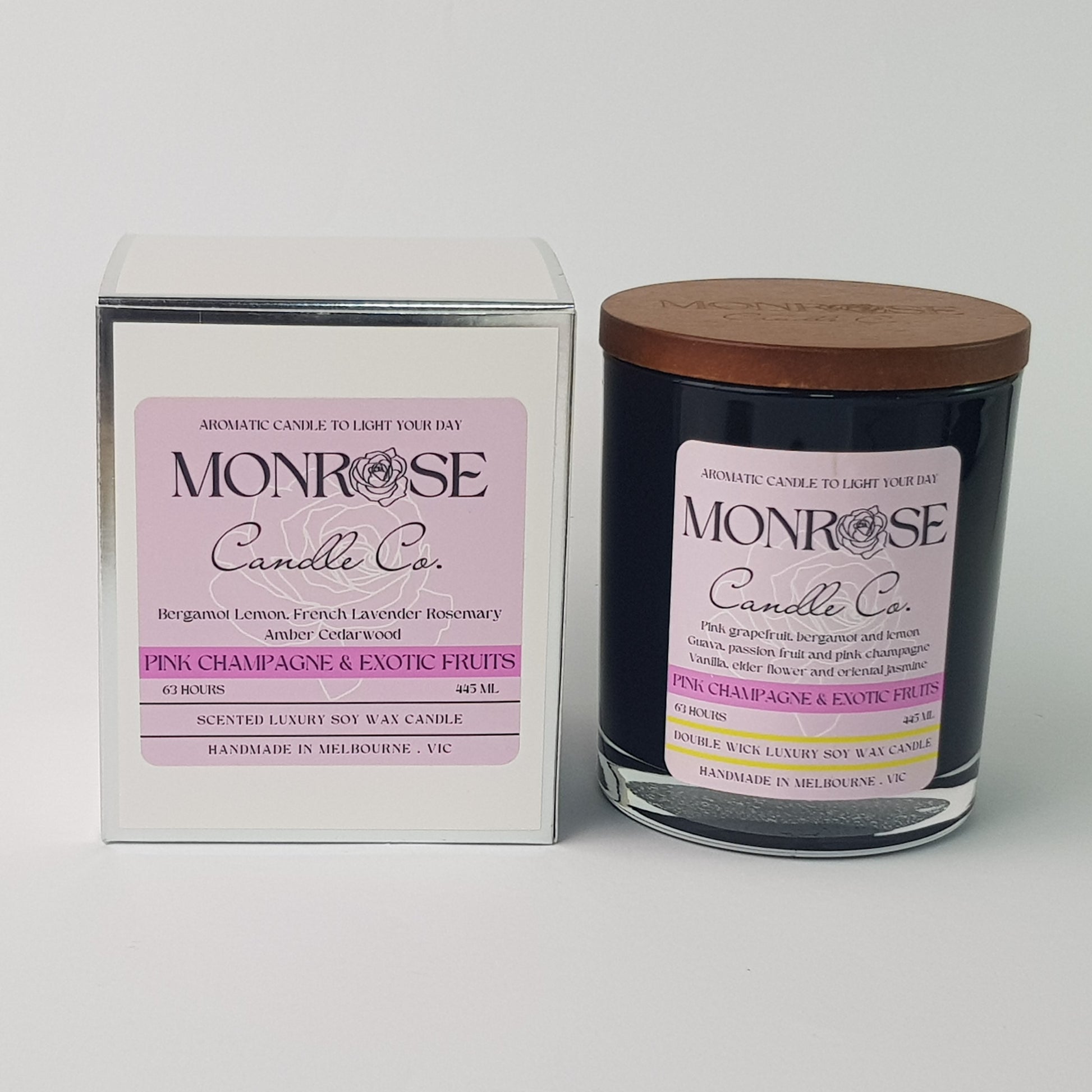Front view of a black jar candle with pink champagne & exotic fruits fragrance and a cotton wick, containing 395 grams of soy wax and offering 63 hours of burn time.
