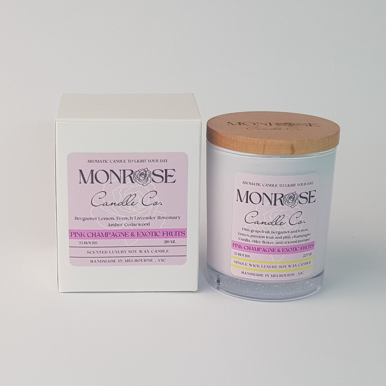 Front view of a white jar candle with "pink champagne & exotic fruits" fragrance and a cotton wick, containing 185 grams of soy wax and offering 33 hours of burn time.