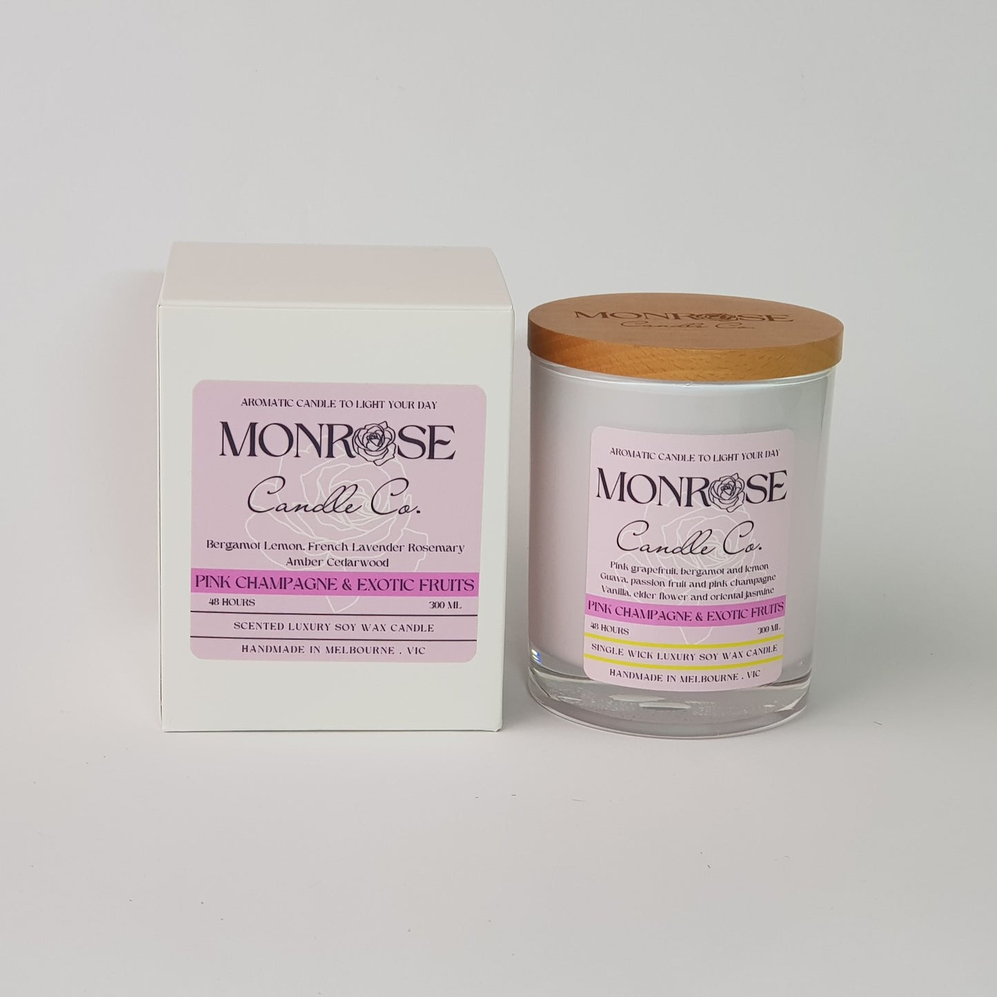 Front view of a white jar candle with "pink champagne and exotic fruits" fragrance and a cotton wick, containing 265 grams of soy wax and offering 48 hours of burn time.