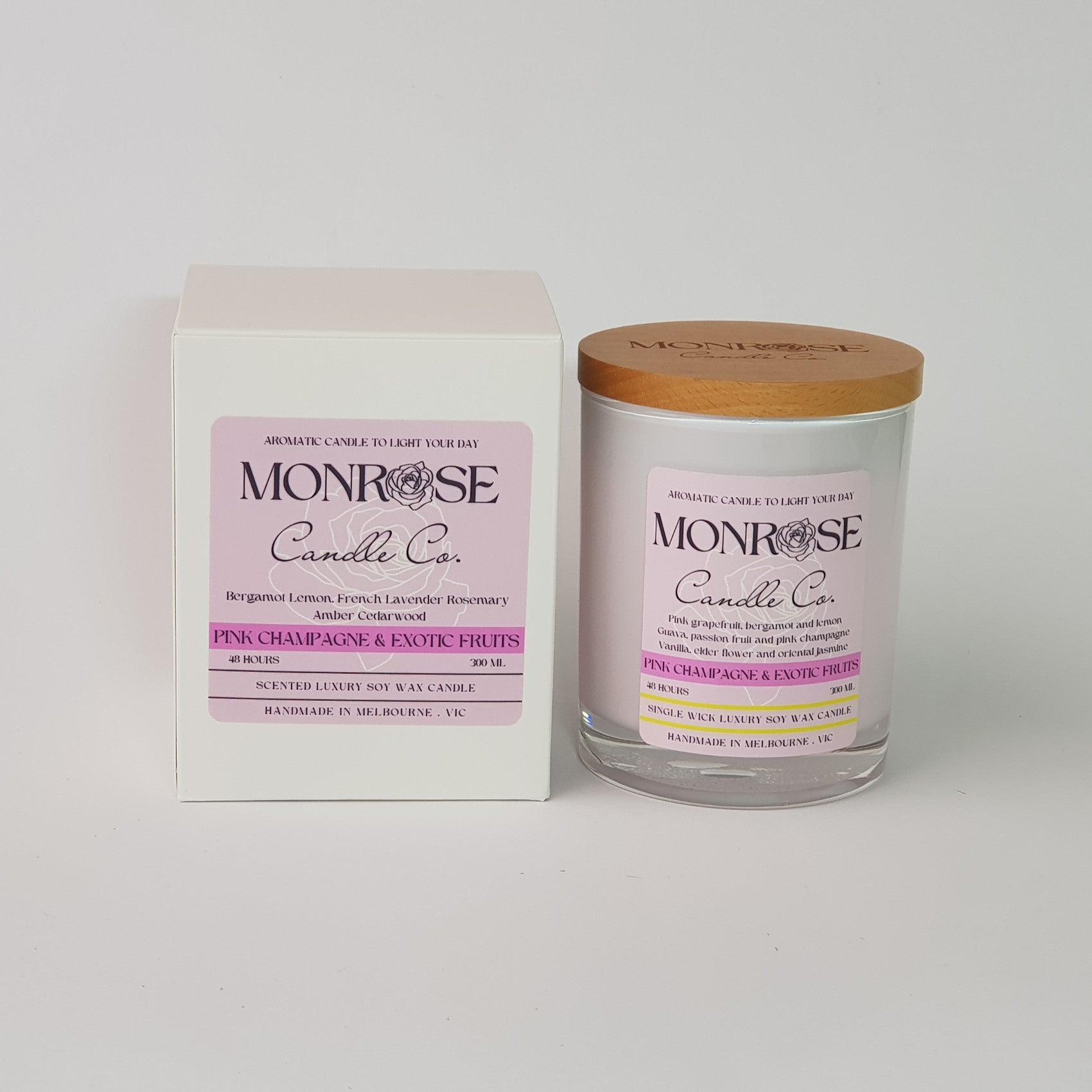 Front view of a white jar candle with "pink champagne and exotic fruits" fragrance and a cotton wick, containing 265 grams of soy wax and offering 48 hours of burn time.