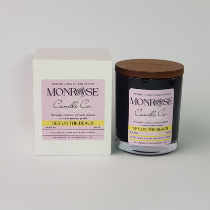 Front view of a black jar candle with "Sex on the beach" fragrance and double cotton wick, containing 265 grams of soy wax and offering 48 hours of burn time.