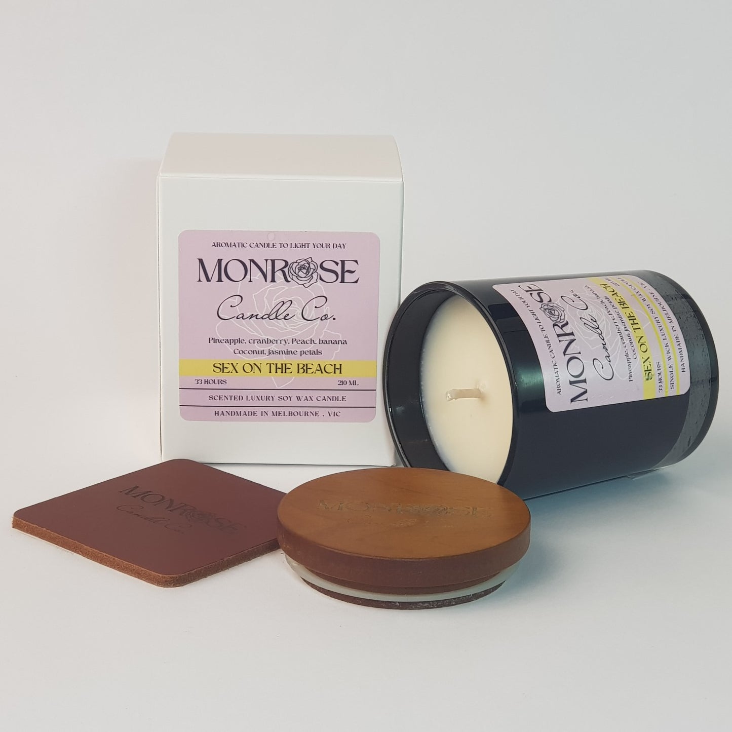 Front view of a black jar candle with "Sex on the beach" fragrance and a cotton wick, containing 185 grams of soy wax and offering 33 hours of burn time.