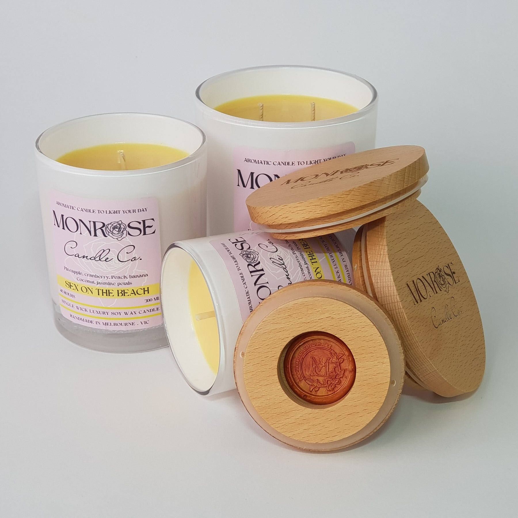 Front view of "Sex on the beach" candle collection in white jars with cotton wicks.