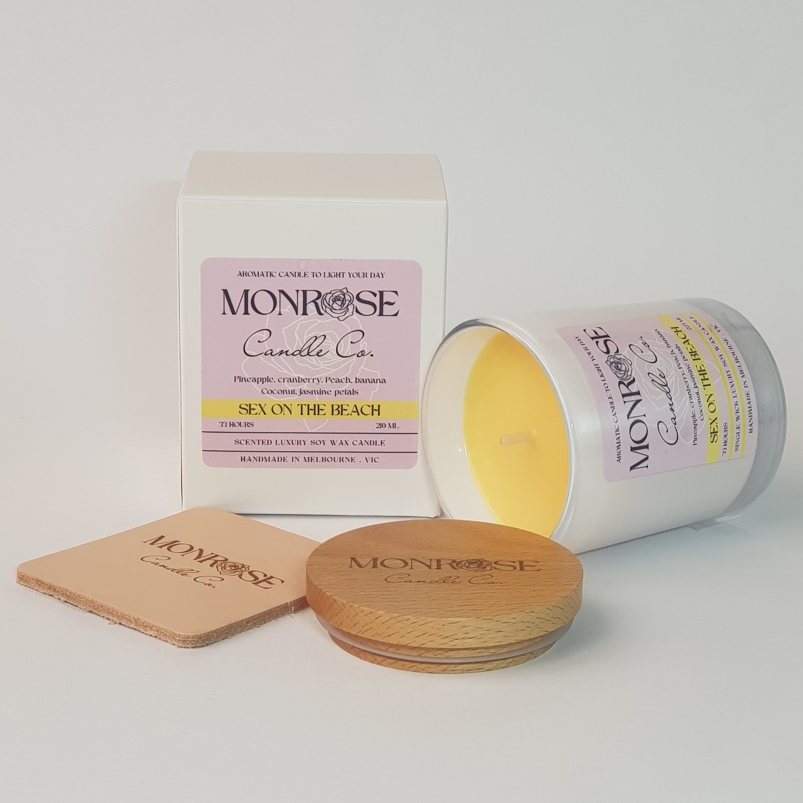 Side view of a white jar candle with "Sex on the beach" fragrance and a cotton wick, containing 185 grams of soy wax and offering 33 hours of burn time.