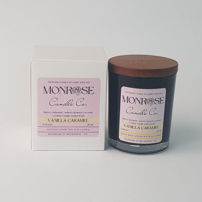 Front view of a black jar candle with "vanilla caramel" fragrance and a cotton wick, containing 185 grams of soy wax and offering 33 hours of burn time.