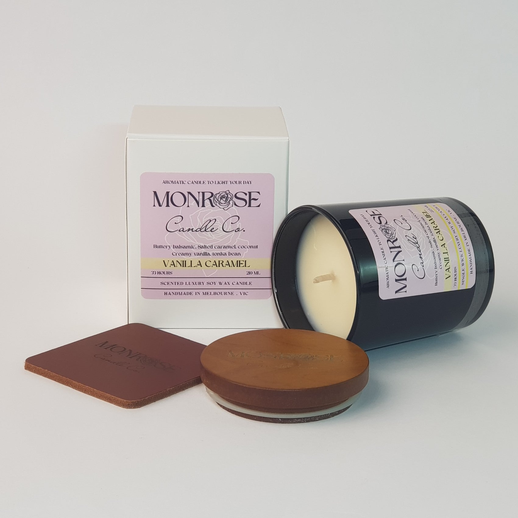 Side view of a black jar candle with "vanilla caramel" fragrance and a cotton wick, containing 185 grams of soy wax and offering 33 hours of burn time.