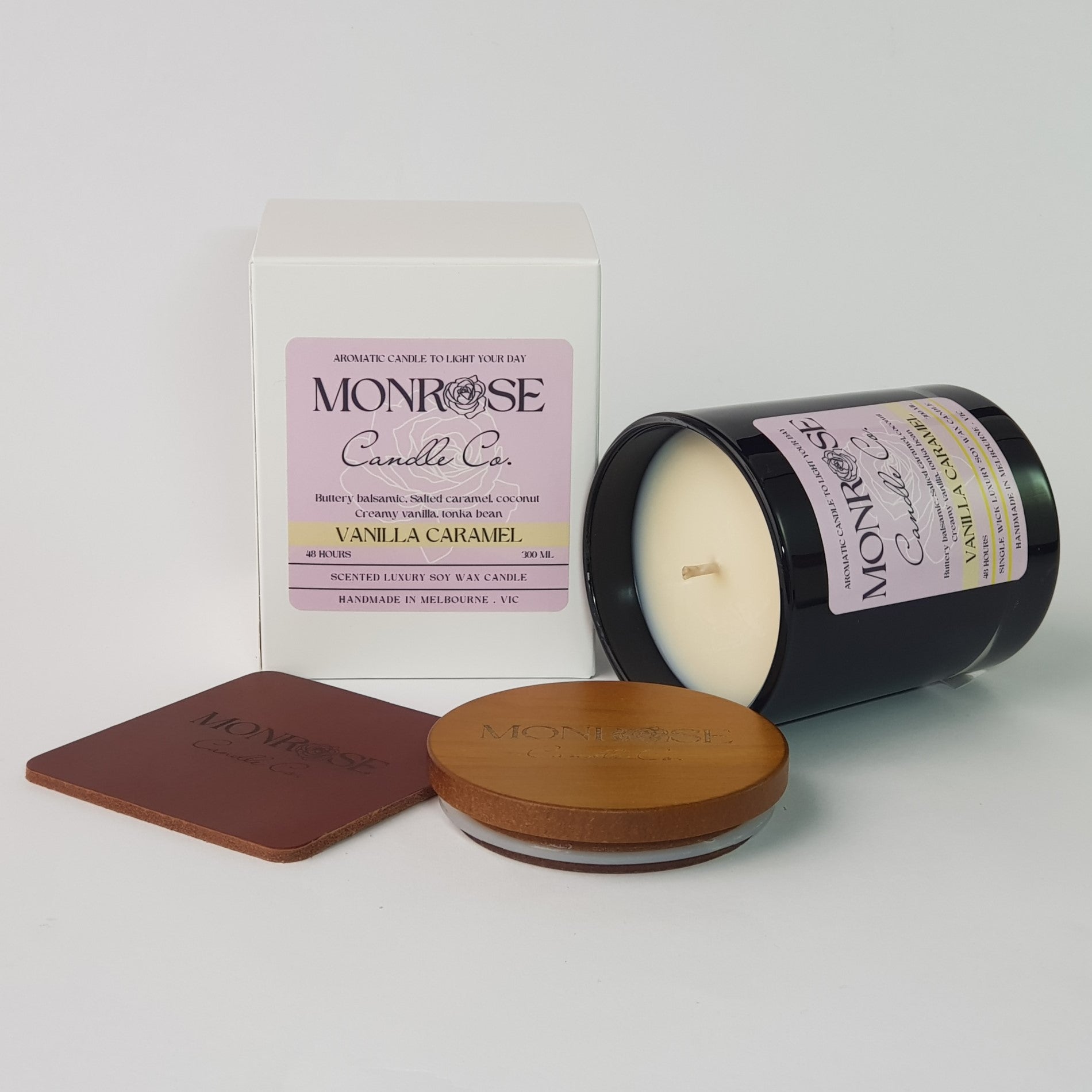 Side view of a black jar candle with "vanilla caramel" fragrance and a cotton wick, containing 265 grams of soy wax and offering 48 hours of burn time.