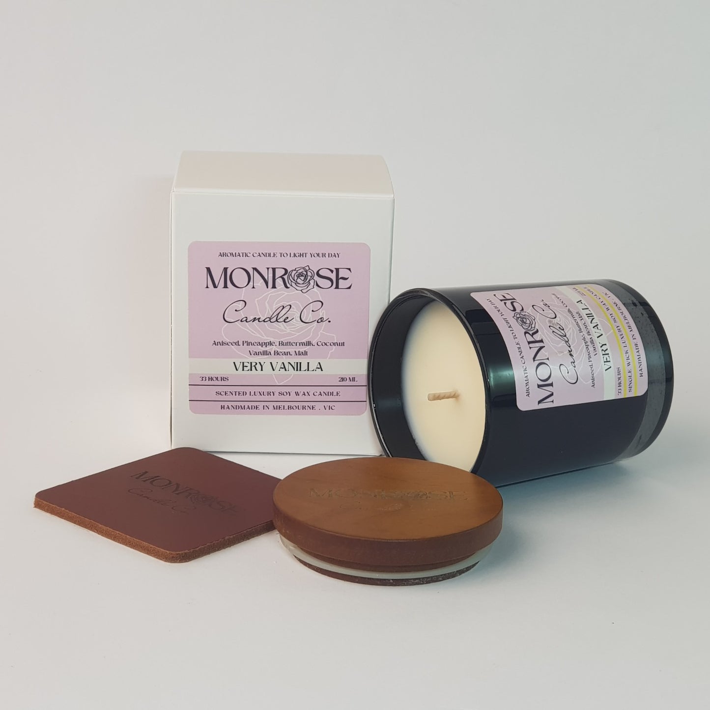Side view of a black jar candle with the "very vanilla" fragrance and a cotton wick, containing 185 grams of soy wax and offering 33 hours of burn time.