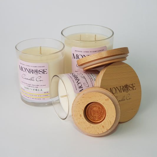 Front view of "very vanilla" fragrance candle collection in clear jars with cotton wicks. 