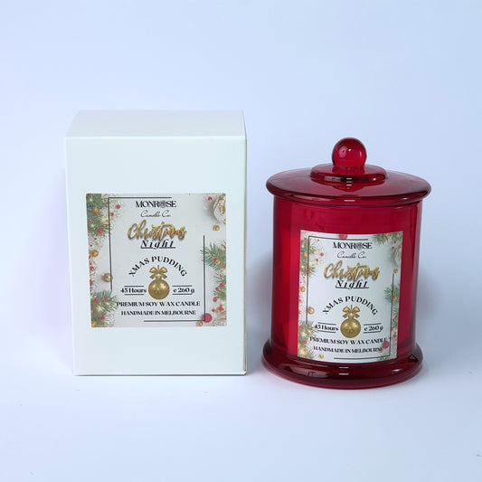 Front view of a scented candle in a red jar with "Christmas Pudding" fragrance and a cotton wick, containing 260 grams of soy wax and offering 45 hours of burn time.